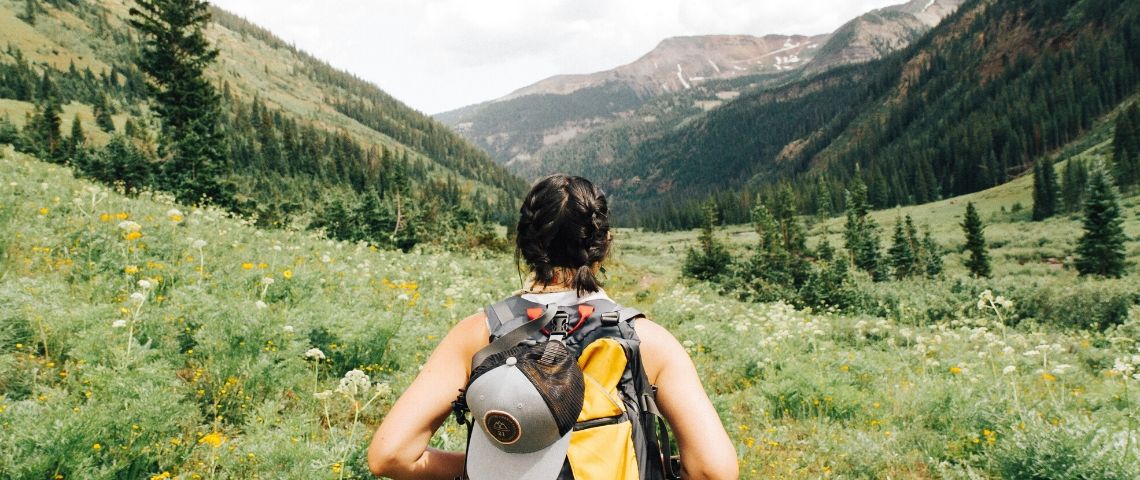 Tourisme : la tendance de la micro-aventure Une femme de dos avec un sac de randonnée