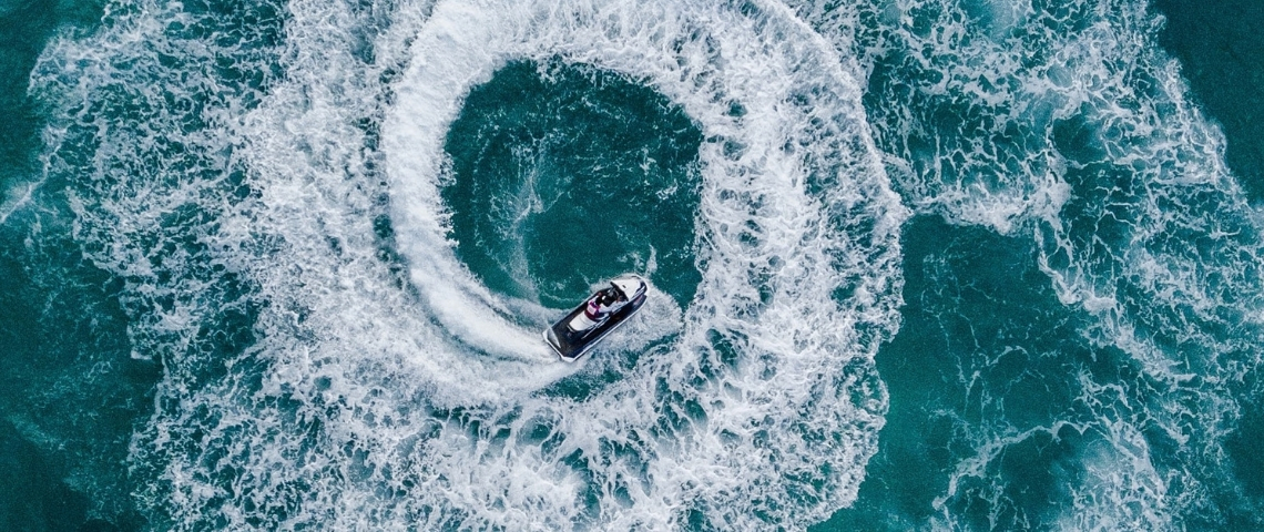 Comment les entreprises peuvent-elles mesurer leur impact sur l'océan ? Un bateau en train de faire des cercles dans la mer
