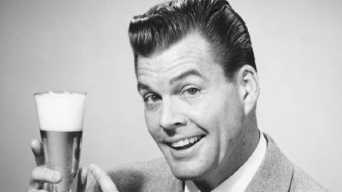 Pub vintage montrant un homme qui pointe un verre de bière