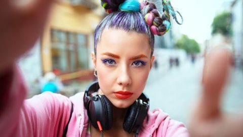 Une femme avec les cheveux colorés qui regarde la caméra