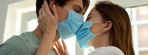 L'impact de la pandémie de Covid-19 sur nos relations sexuelles Un couple qui s'embrasse avec des masques
