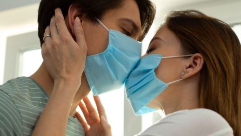 Un couple qui s'embrasse avec des masques