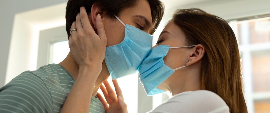 Un couple qui s'embrasse avec des masques