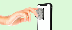 une main insérant une pièce de monnaie dans un smartphone