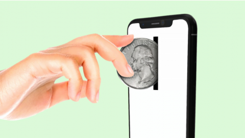 une main insérant une pièce de monnaie dans un smartphone