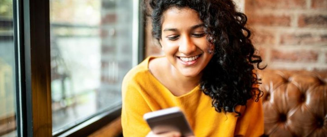 Comment les néo banques ont changé le système bancaire ? Une femme avec son mobile
