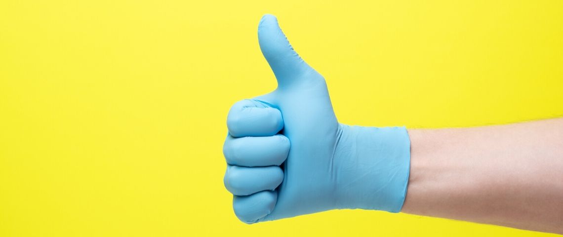 Comment affronter les crises Main pouce levé ganté et sur fond jaune