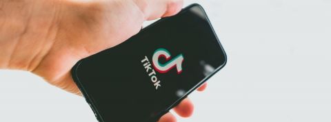 Comment TikTok devient une arme diplomatique Main tenant smartphone avec TikTok