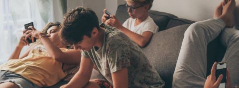 Les ados et leur smartphone Un groupe d'ado en train de regarder leur portable.