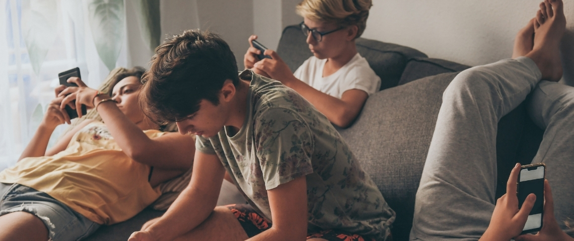 Les ados et leur smartphone Un groupe d'ado en train de regarder leur portable.
