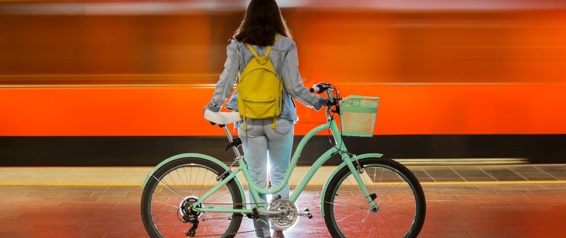 Les initiatives pour survivre à la crise Une femme de dos avec un vélo devant un fond rouge