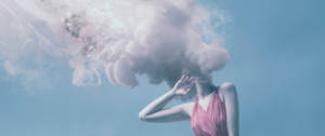 Une femme avec la tête dans de la fumée rose