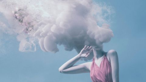 Une femme avec la tête dans de la fumée rose