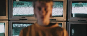 une femme floutée devant des écrans de télévision