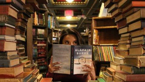 une femme lit dans une bibliothèque