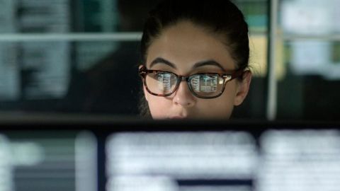 Une femme derrière un ordinateur avec plein de data
