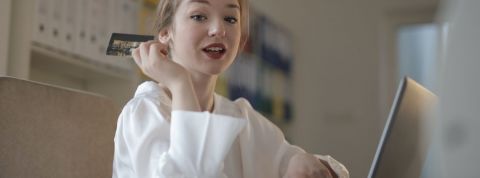 La génération N, les consommateurs post-confinement Une femme devant un écran d'ordinateur avec une carte bancaire