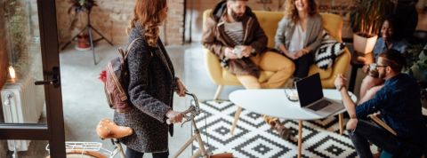 Great Place To Work dévoile son palmarès 2020 Une femme entrant dans son bureau avec son vélo