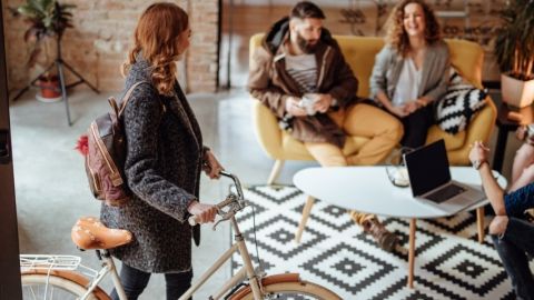 Une femme entrant dans son bureau avec son vélo