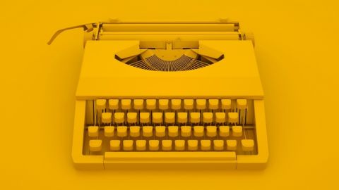 une machine à écrire sur fond jaune