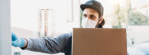 Des livreurs Amazon accrochent leurs smartphones dans des arbres pour travailler plus Un livreur avec un colis sonne à la porte d'une personne.