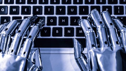 mains robotiques tapent sur un clavier d'ordinateur