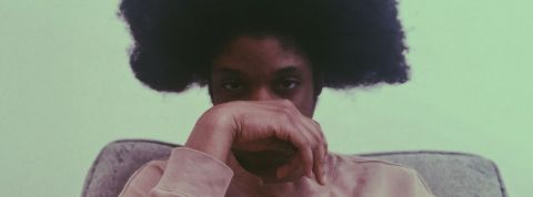 L'anxiété sociale est-elle le nouveau mal des ados ? Un jeune homme noir avec une coupe afro et sa main devant le visage