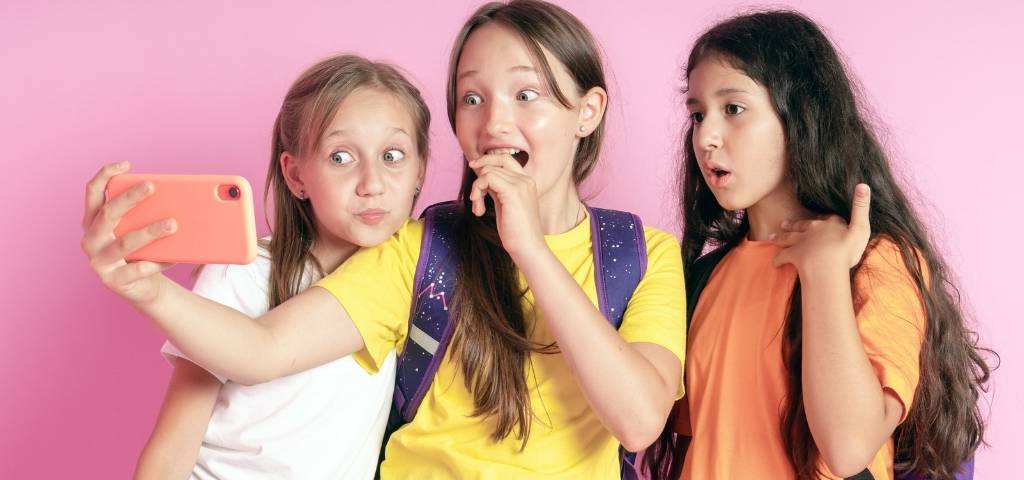 Qui prendra la place du TikTok ? trois adolescentes qui regardent leur portable
