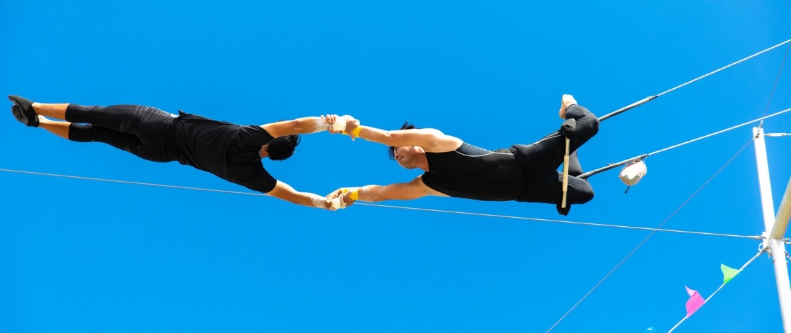 Comment devenir une HRO ? Deux trapézistes en train de faire des acrobaties
