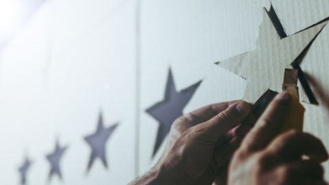 Homme en train de fixer une étoile en carton