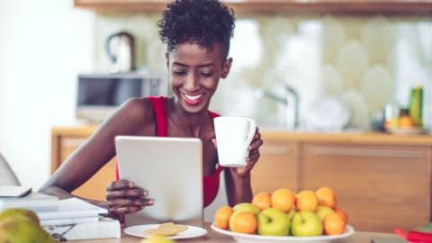 Une femme assise regarde sa tablette
