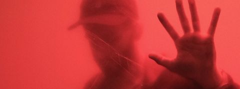 Comment ça se passe quand on est cancel ? Un homme derrière une parois rouge.