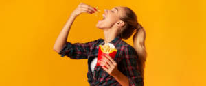 Une jeune femme en train de manger des frites McDonald's