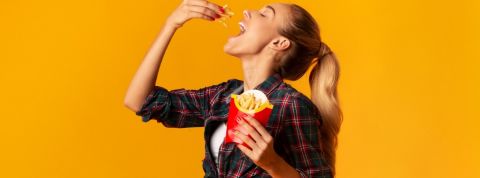 Quelles sont les marques préférées des millennials ? Une jeune femme en train de manger des frites McDonald's
