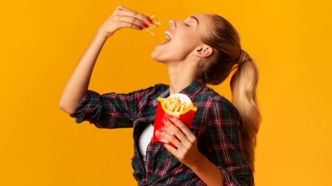 Une jeune femme en train de manger des frites McDonald's