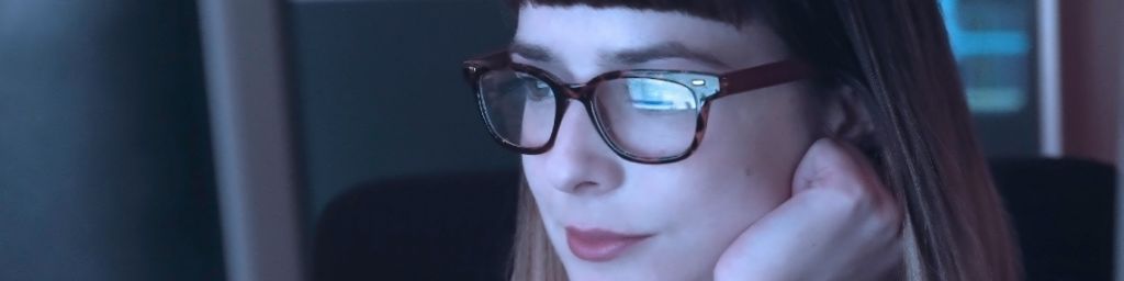 Femme portant des lunettes devant un ordinateur