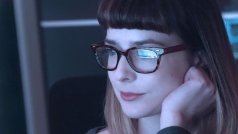 Femme portant des lunettes devant un ordinateur