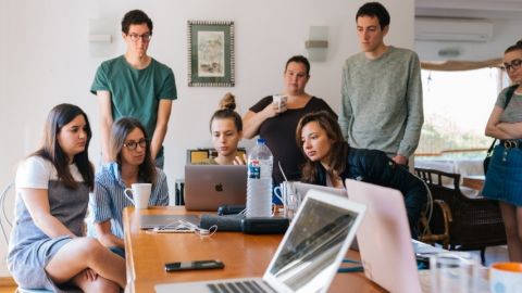 Un groupe d'adolescents en train de travailler en groupe autour d'ordinateurs