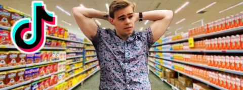 L'opara de l'épicerie un jeune homme dans les rayons dans un raypn de supermarché