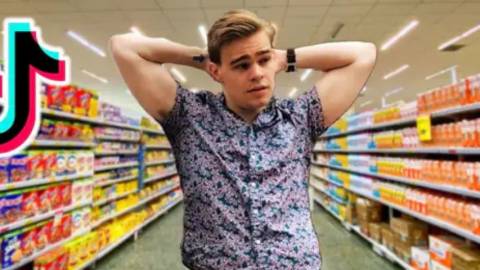 L'opara de l'épicerie un jeune homme dans les rayons dans un raypn de supermarché
