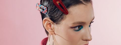 Comment le travail du sexe en ligne change de visage Une femme avec des barrettes colorées dans les cheveux sur fond rose