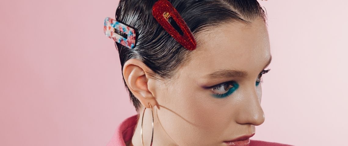 Comment le travail du sexe en ligne change de visage Une femme avec des barrettes colorées dans les cheveux sur fond rose