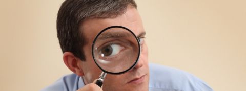 Comment Slack peut être un outil de surveillance Homme tenant une loupe