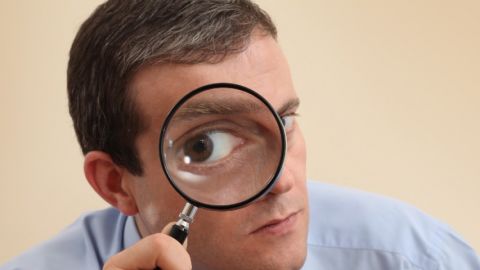 Comment Slack peut être un outil de surveillance Homme tenant une loupe