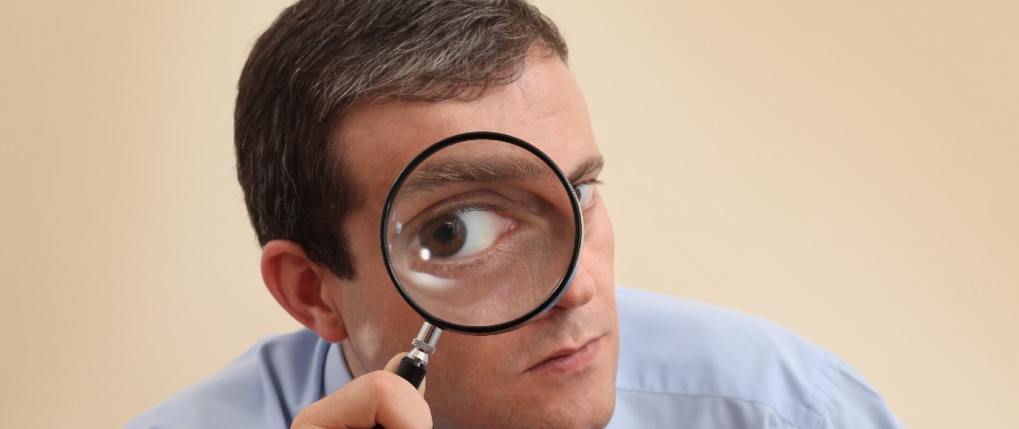 Comment Slack peut être un outil de surveillance Homme tenant une loupe