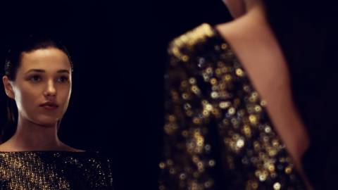 une jeune fille brune se regarde dans le miroir