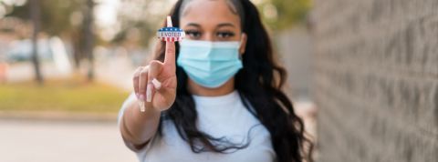 Génération AOC : les jeunes Américains et la politique Une jeune femme tenant le sticker - I voted -