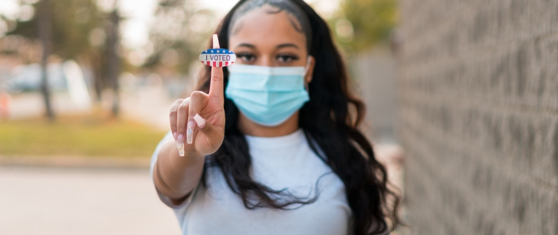 Génération AOC : les jeunes Américains et la politique Une jeune femme tenant le sticker - I voted -