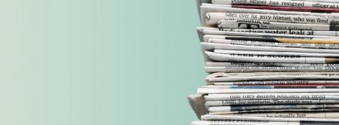 Nos 6 newsletters tech favorites Tas de journaux sur fond vert.