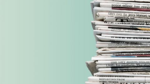 Tas de journaux sur fond vert.